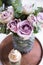 Pastel purple, mauve color fresh summer roses in vase in tray cl