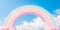 pastel rainbow arch against a bright blue sky, symbolizing hope and joy associated with spring.