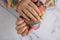 Pastel softness colorful manicured nails. Woman showing her new summer manicure in colors of pastel palette. Simplicity