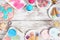 Pastel summer sweets frame over a rustic white wood background