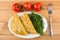 Pasties and dill in oval dish, tomatoes and fork