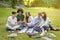 Pastime In Campus. Group Of College Friends Resting Outdoors After Classes