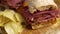 Pastrami sandwhich with delicious meet on baguette bread with chedder cheese, onion