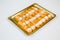 Pastries in a gold tray on white background