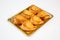 Pastries in a gold tray on white background