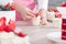 Pastry chef confectioner young caucasian woman in the kitchen. She is decorating a cupcake