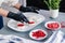 The pastry chef decorates the birds milk souffle cakes with freeze-dried raspberries and strawberries