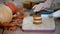 Pastry chef filling mini cake with cream. Making pumpkin mini cakes.