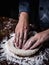 Pastry chef hand kneading Raw Dough with sprinkling white flour