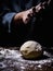 pastry chef hand sprinkling white flour over Raw Dough on kitchen table.