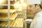 Pastry chef inspecting a tray of biscuits. Conceptual image