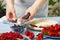 pastry chef lays blueberries on strawberry marshmallow cake