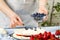 pastry chef lays blueberries on strawberry marshmallow cake