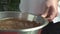 Pastry chef mixes the chocolate and cream in a bowl.