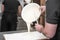 Pastry chef pouring hot cream. Cropped close up of a professional pastry chef preparing filling for desserts at the