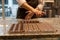 Pastry chef processing chocolate in kitchen. Selective focus of hands and pralines, filling chocolate mold.
