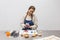 Pastry chef taking picture with her phone of cookies she has just decorated