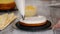 Pastry cook making layer sponge cake with pineapple filling