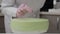 Pastry cook prepares a cake of green, watering it with icing