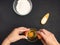 Pastry creation process. A young girl breaks an egg into a transparent bowl, flour, salt