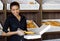 Pastry, service and portrait of a woman in a bakery for work, sales and bread delivery. Smile, small business and a