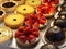 Pastry shop with variety of tarts, cakes, creme brulee, with strawberry, chocolate, lemon, pears and apple slices displayed at sho