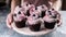 Pastry woman hands hold a round dish of delicious blueberry muffins