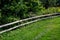 Pasture for artiodactyla on a green lawn with a barrier in the form of a wooden fence.