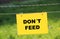 pasture ground with electrical fence and prohibition sign - dont feed