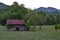 Pasture view with barn, truck, cows, and mountains