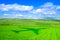 Pastures, sky and clouds and a plane shadow over grass