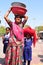 Patan: Indian woman with her two daughters carring water bowls o