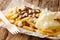 Patatje oorlog is a Dutch street food dish consisting of fries topped with a mayonnaise, finely chopped onions and peanut sauce