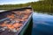 patched-up canoe floating peacefully on lake water