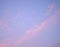 Patches and Lines of Clouds in Blue Sky with hues of Pink - Natural Abstract background