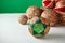 Patchwork puzzle balls and christmas decorations in basket on white and green background