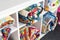 Patchwork, sewing and fashion concept - colorful finished quilts in the studio at white shelves with few storage