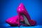 Patent leather shiny female pink stilettos on a blue background