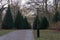 A path bordered with cone shaped topiary on a cold January day in a park in MalmÃ¶, Sweden