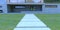 Path of concrete slabs to the entrance to a futuristic three-story country-style building. Porch and wall decoration - decorative