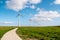 Path by the dike to the huge windmill park with huge turbines in the Netherlands Noordoostpolder, green energy wind mill