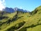 Path in grass mountains, cows and pointy rocks