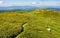 Path through grassy meadow to huge boulders