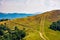 Path through grassy meadows on mountain ridge