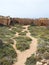 Path leading to caves and graves carved into the rock face near the sea at the tomb of the kings area in paphos cyprus