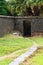 Path leads to a secret doorway in an ancient wall with jungle beyond