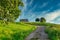 Path through lush green grass leading to small stone cottage in Spanish countryside