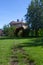 A path made of round pieces of wooden logs in a lawn that leads to a house