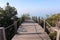 path made of wooden roasts, wooden bridge leading to the blue horizon over a sandy and overgrown cliff