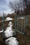 A path with melting snow passing through the gate and running away into the distance